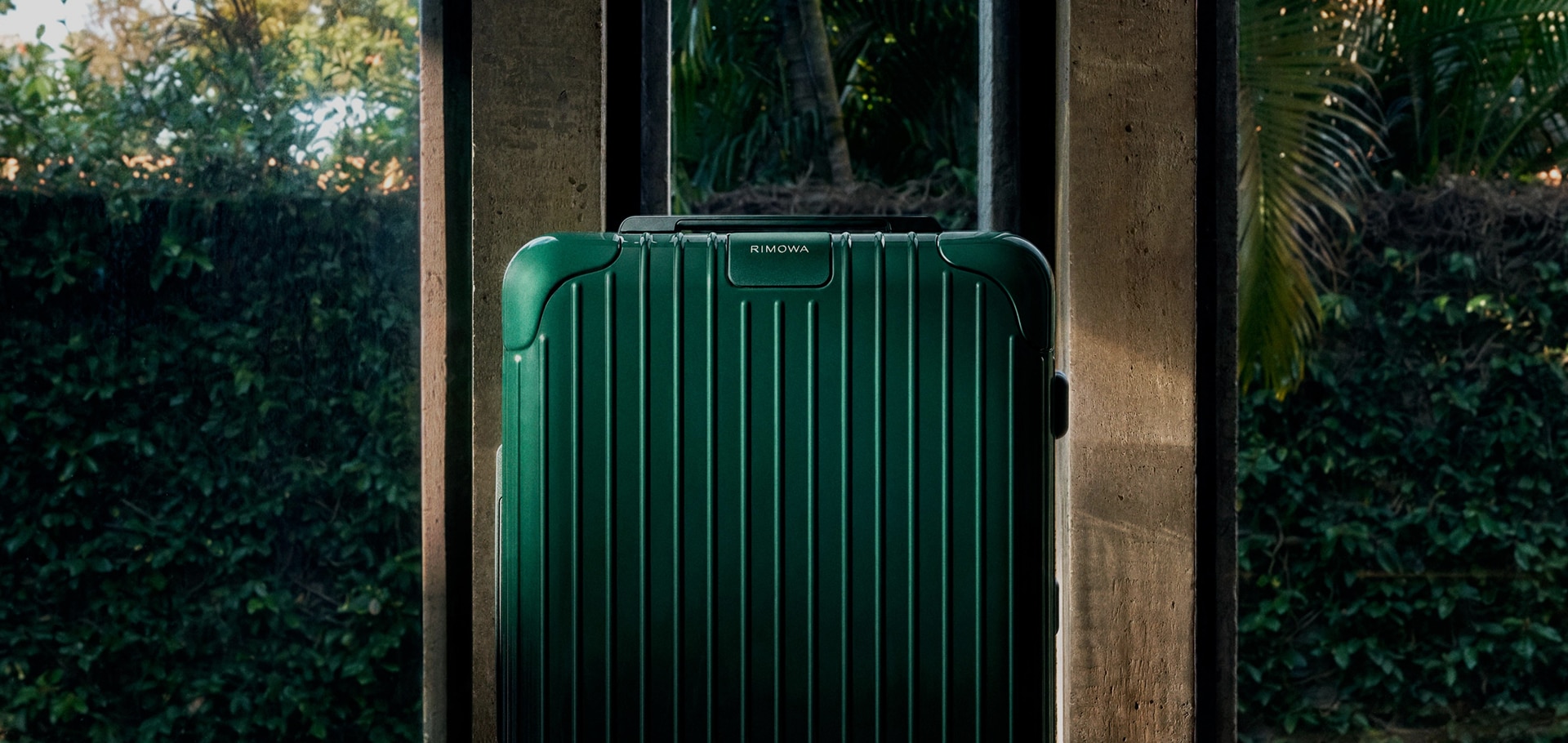 Green RIMOWA suitcase standing outdoors